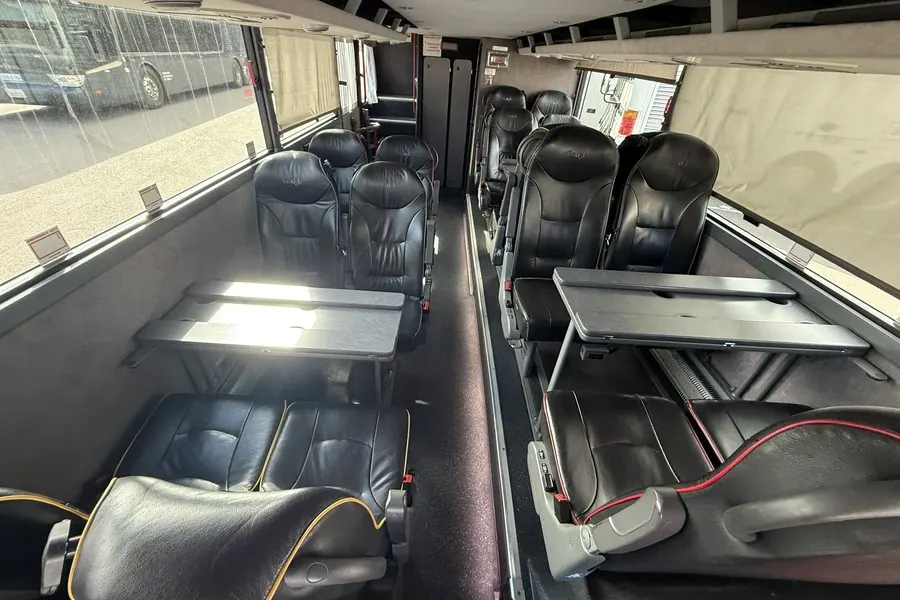 Lower deck of a Van Hool Astromega double-decker with facing leather seats and fold-out tables